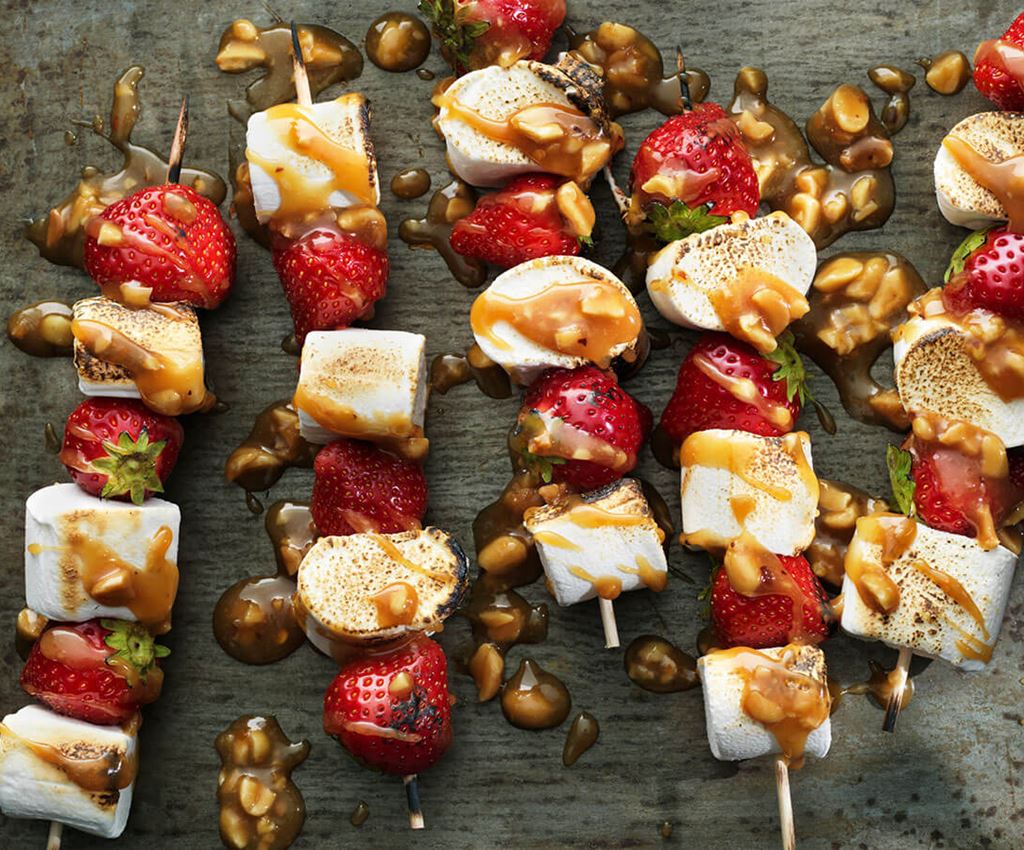 Skewers with strawberries and marshmallows drizzled with caramel sauce