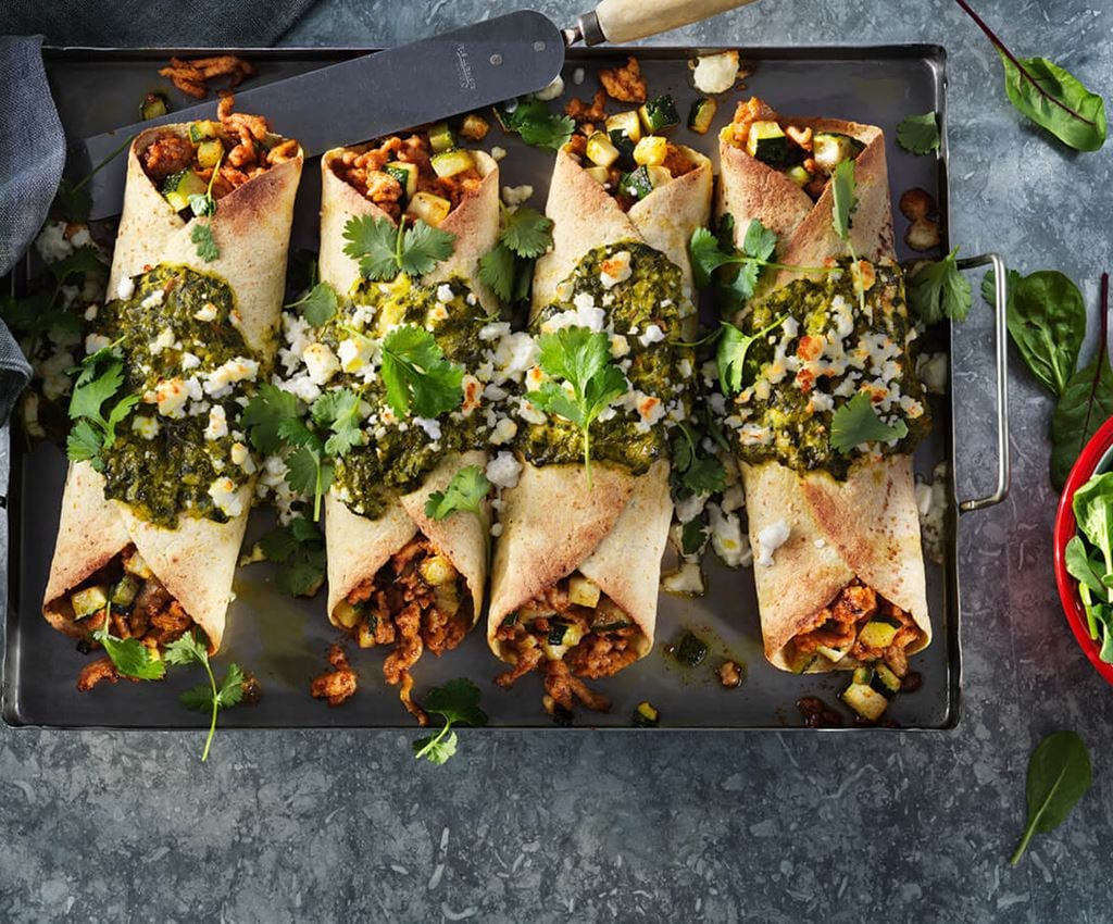 vier enchilada’s met spinazie en kip op een bord