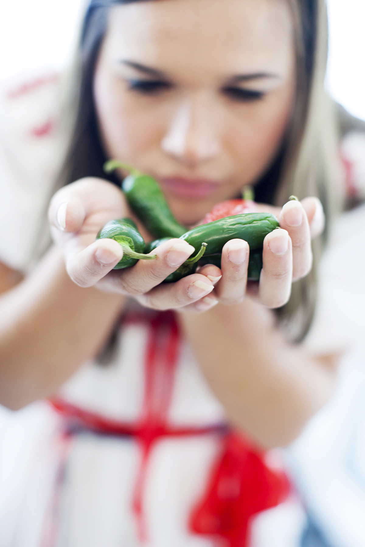 Woman smells green chilli