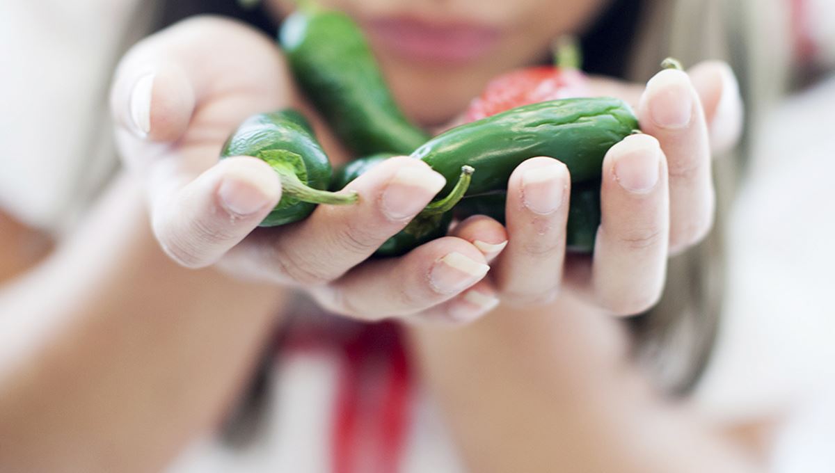 Woman smells green chilli 