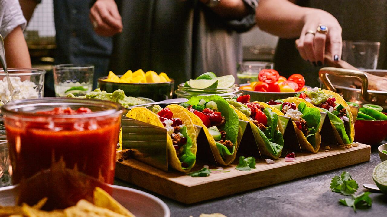 Uppdukad tacobuffé med människor i bakgrunden