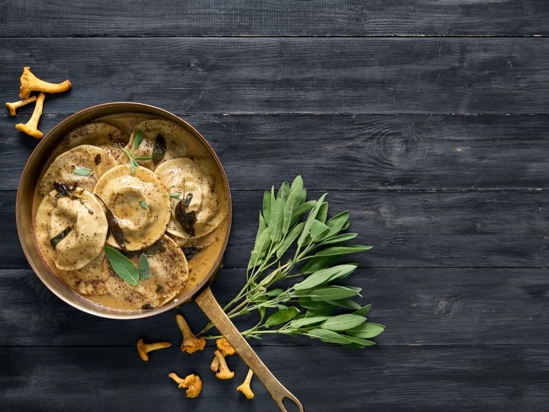 panna ar gaileņu ravioli uz koka galda