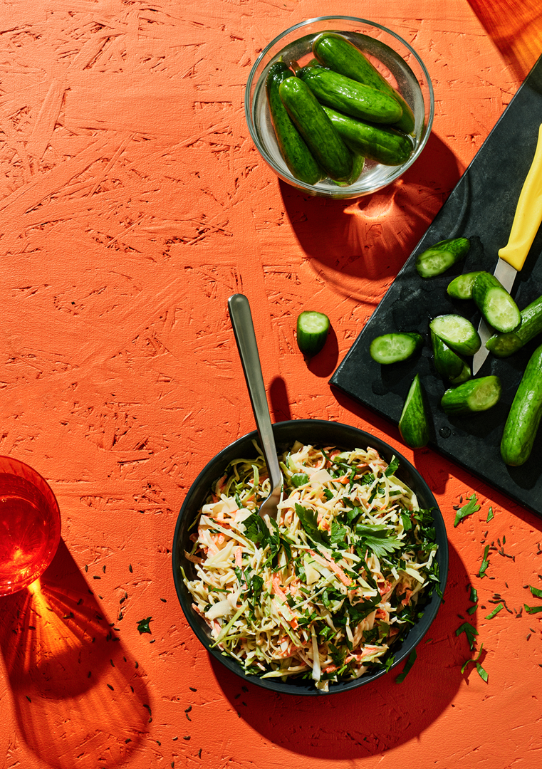 Hurtigsaltet agurk og coleslaw serveret på et bord
