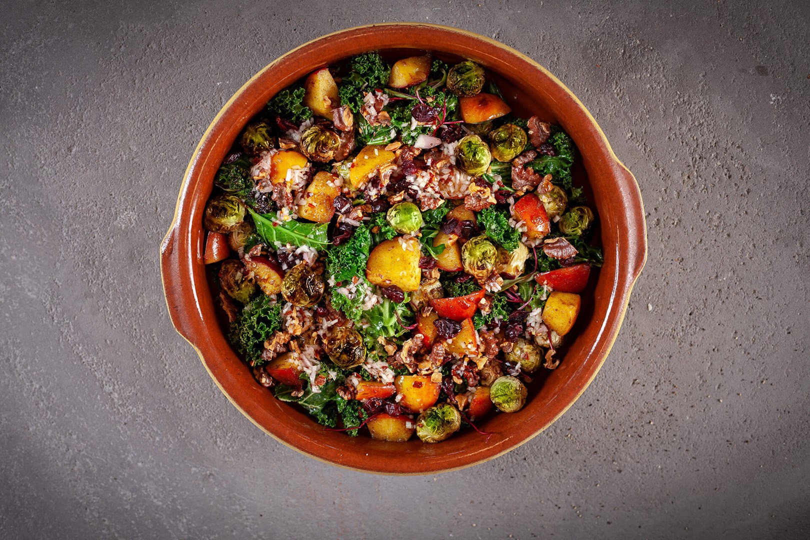 Salad with brussels sprouts, kale, apple and walnuts on a large plate