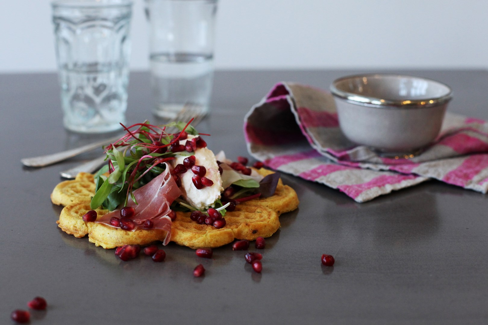 Curryvåfflor med getostcrème, parmaskinka och granatäpple