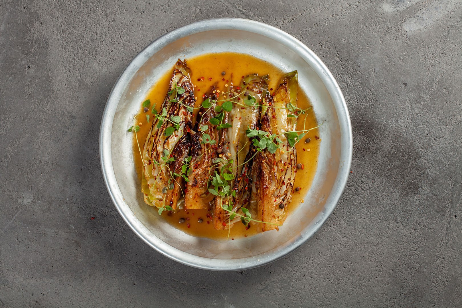 Four pieces of boiled and fried pointed cabbage in a pan