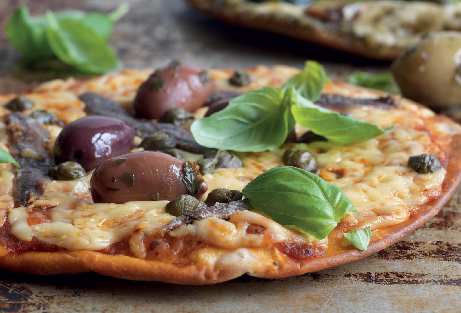Pizza med sardeller, kapris och oliver
