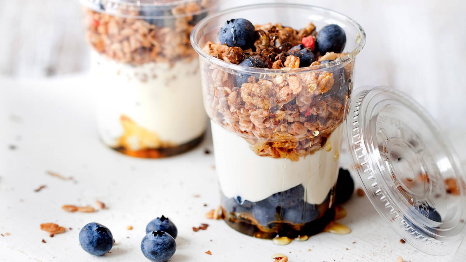 Granola with blueberrys and crème fraiche in a plastic cup