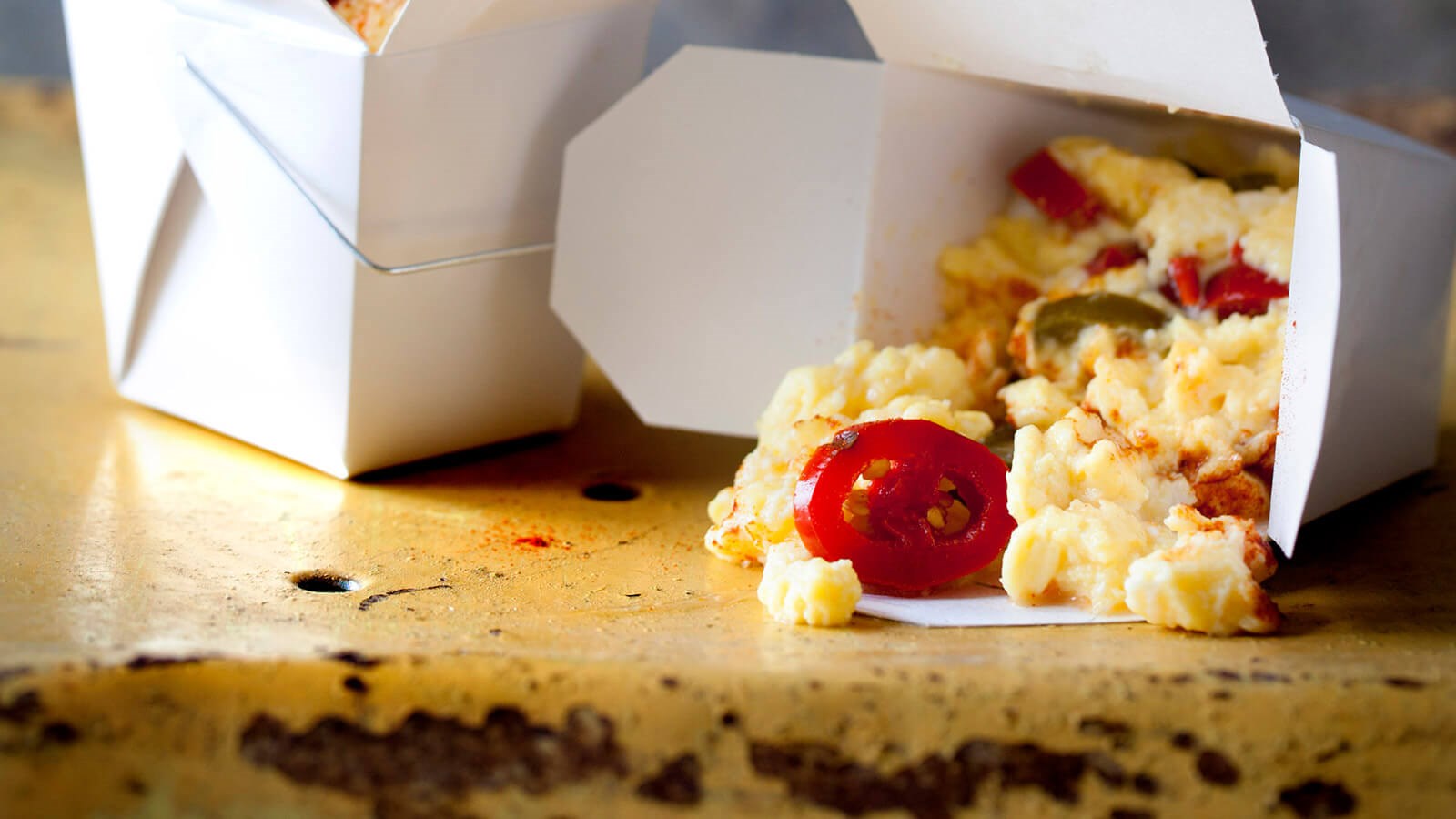 Scrambled eggs with jalapeño in take away boxes