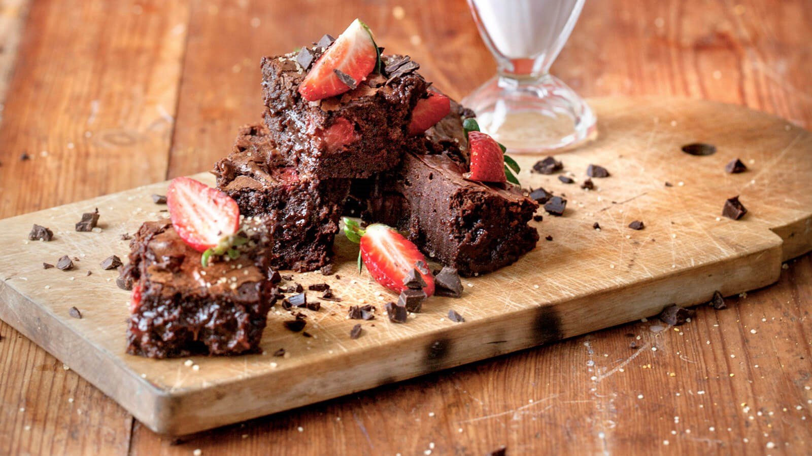 Chocolate brownies with straberries on a wooden board