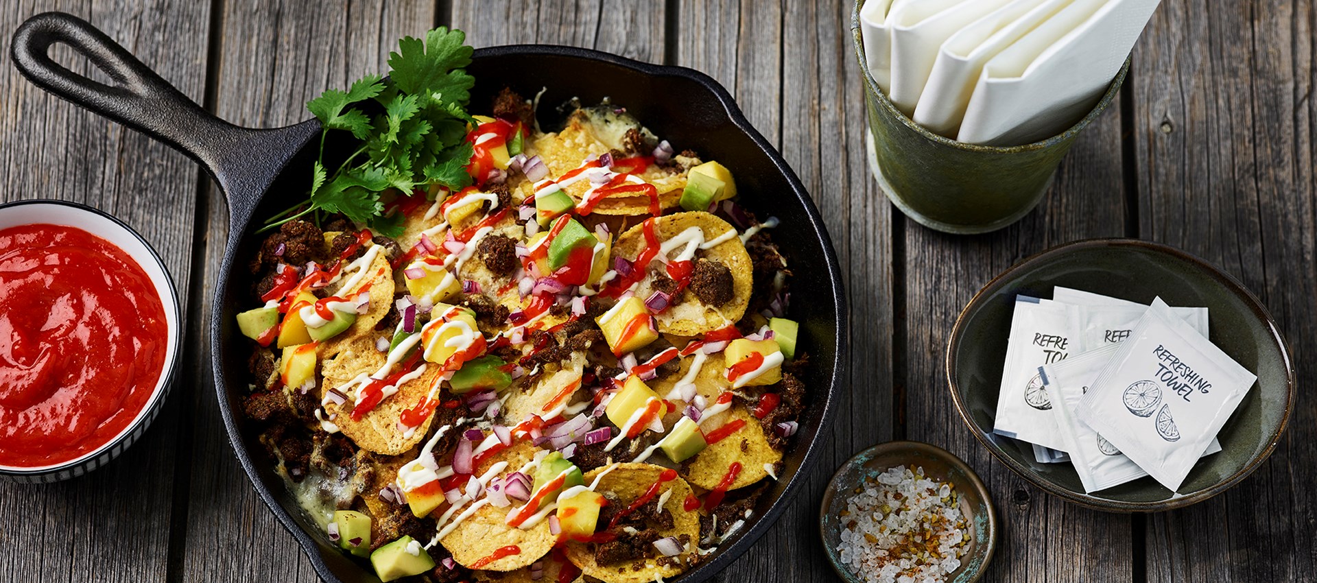 Nacho plate met loaded nachos met Jamaican Jerk pulled oats en mango