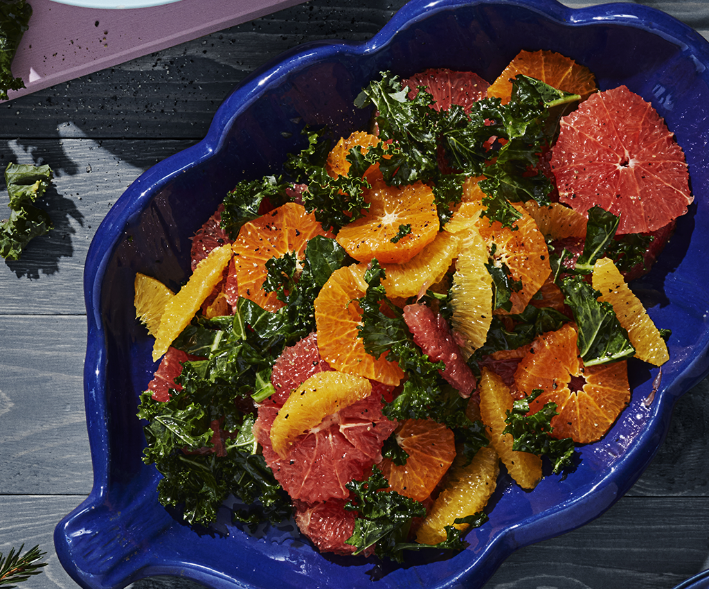 citrussallad med grapfrukt, apelsin och grönkål i en skål serverad på ett bord