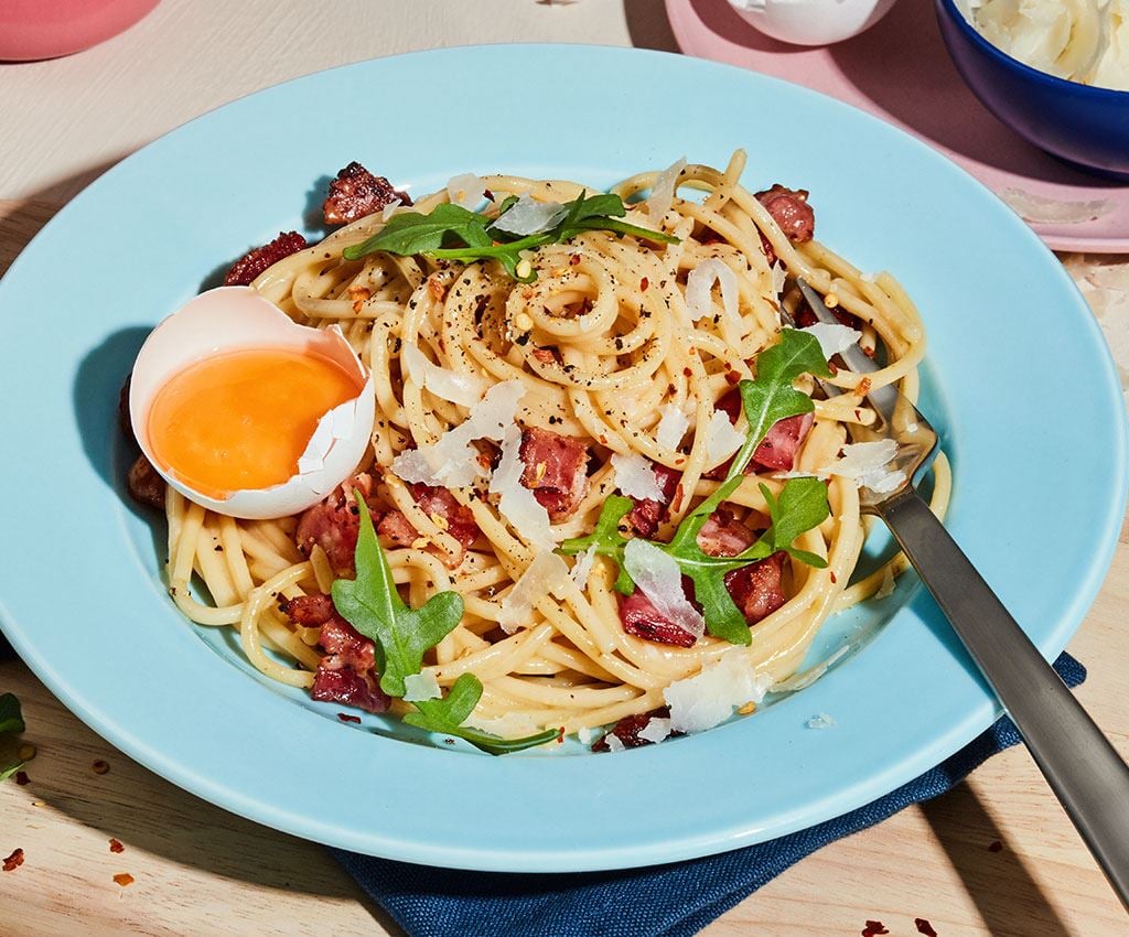 Pikantā Pasta Carbonara šķīvī uz galda