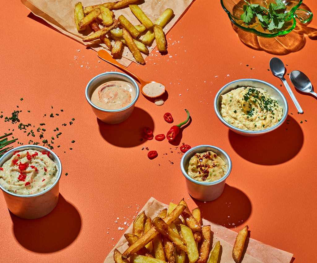 Dressing och såser serveraAmerikkalainen Hampurilaiskastikede på bord med pommes