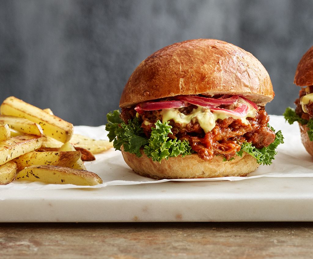 Divi burgeri ar kartupeļiem uz galda