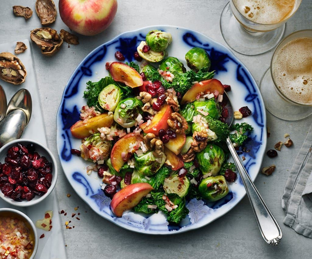Salad with brussels sprouts, kale, apple and walnuts on a large plate
