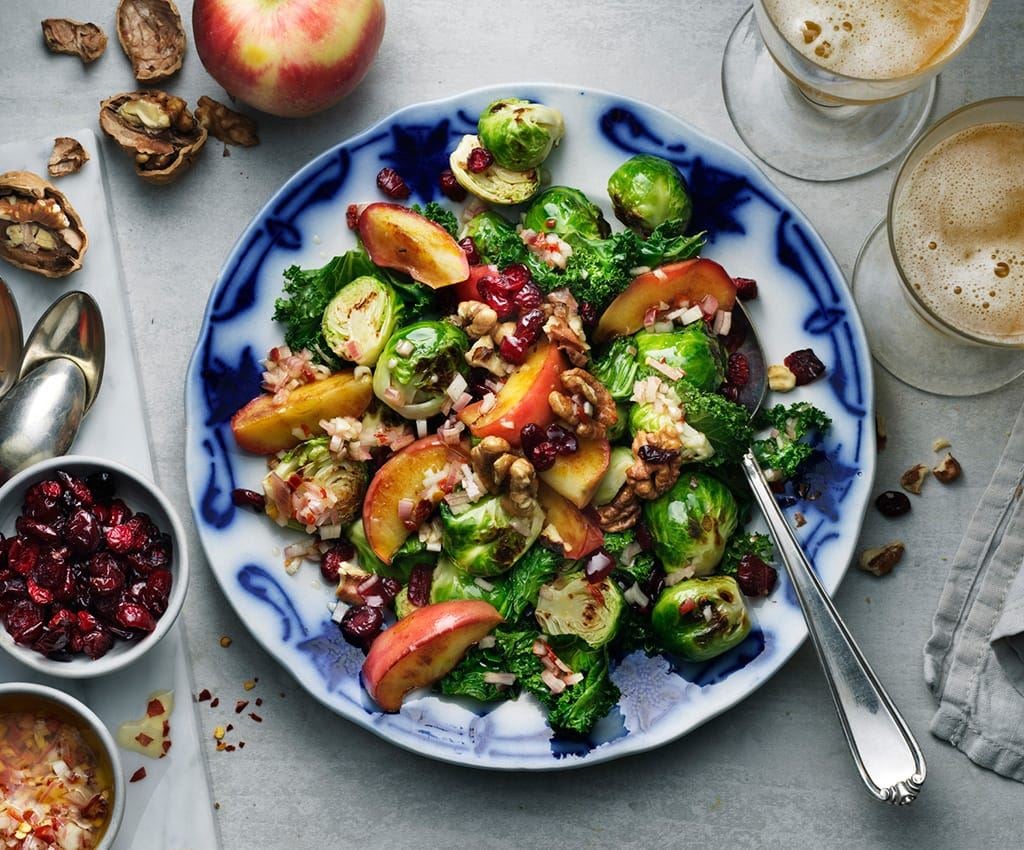 Sallad med brysselkål, grönkål, äpple och valnötter i en stor form