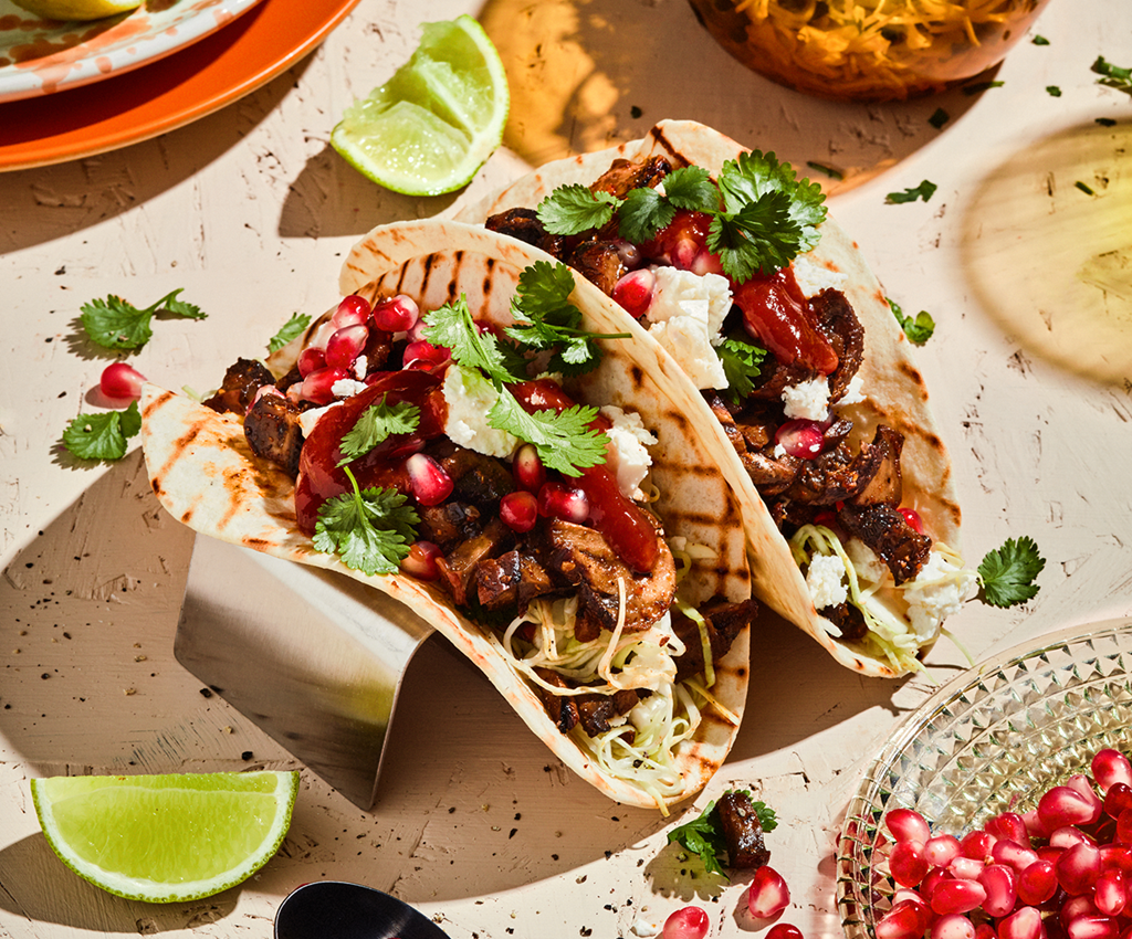 tacos fyldt med svampe serveret med tilbehør på et bord
