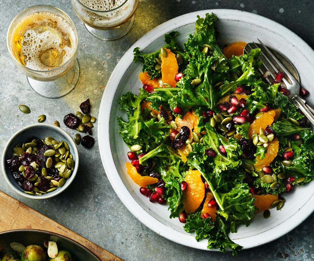 Salade van boerenkool met sinaasappel en granaatappel in een slakom