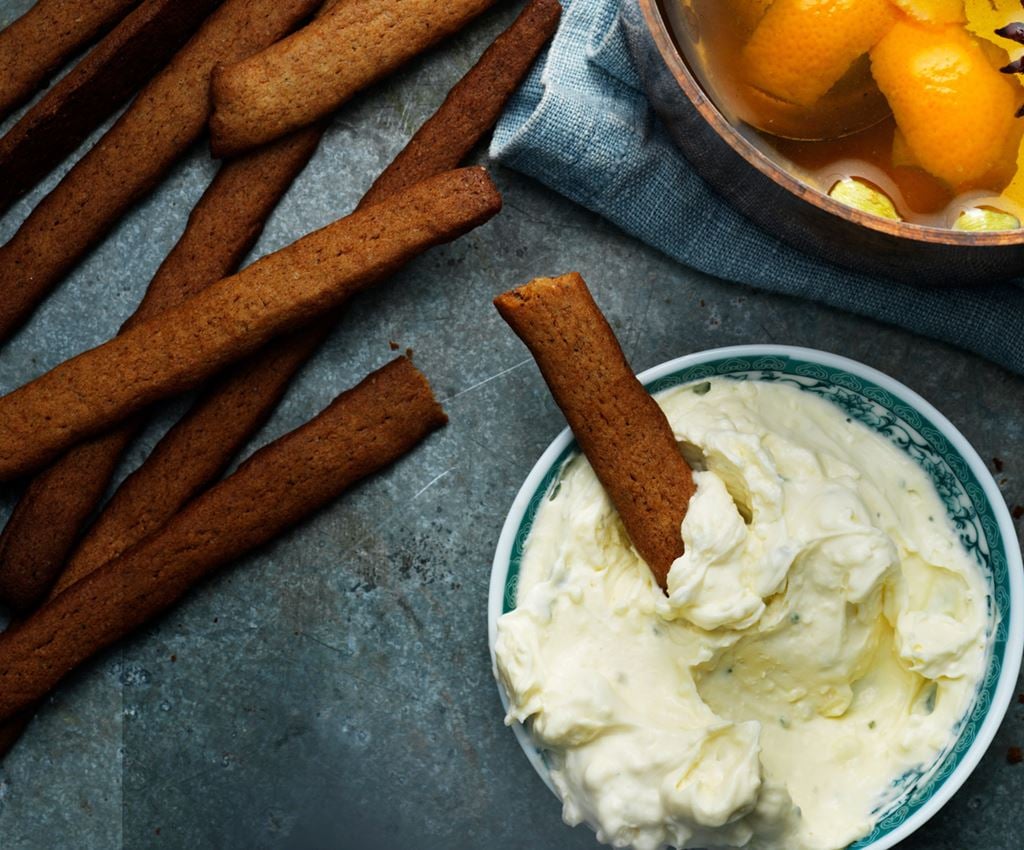 Sticks of gingerbread grissini with a bowl of whipped blue chees