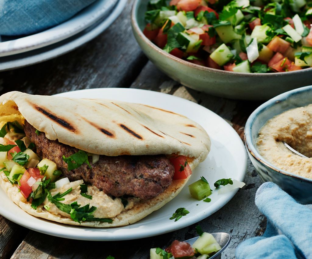 Shish kebab med pitabröd, hummus och hackad tomat- och gurksallad