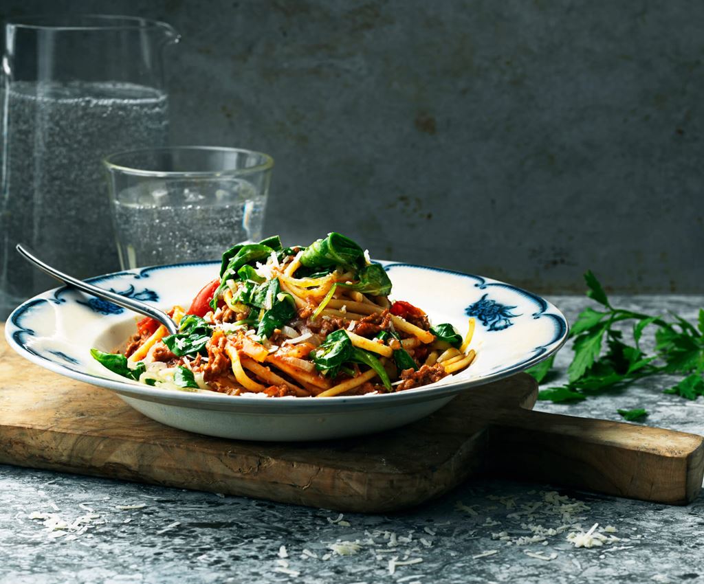 Bolognese med spenat och pasta på en tallrik