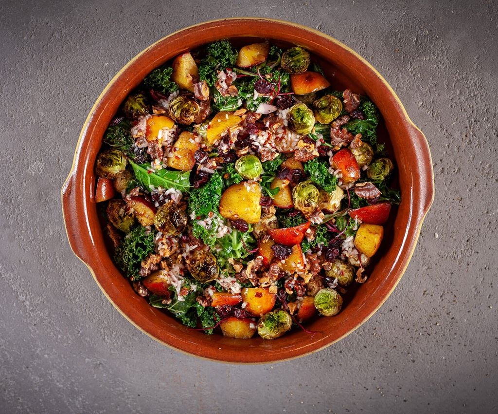 Salad with brussels sprouts, kale, apple and walnuts on a large plate