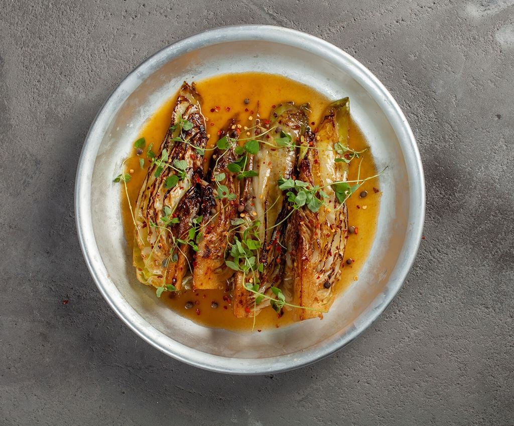 Four pieces of boiled and fried pointed cabbage in a pan