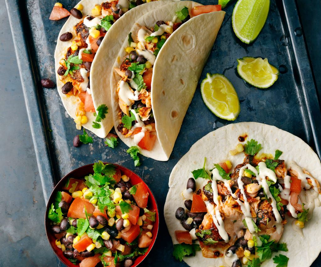 fajita wraps met zalm op een bord met limoen en koriander