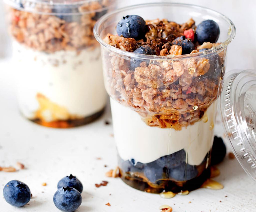 Granola with blueberrys and crème fraiche in a plastic cup