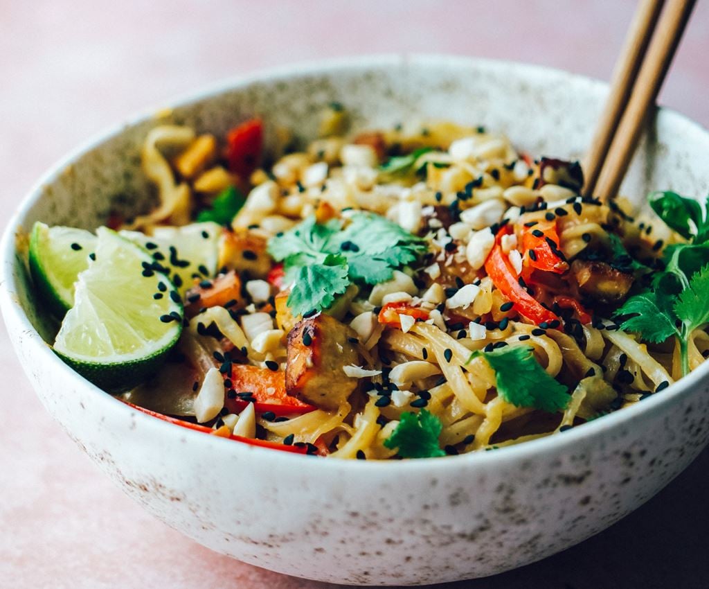 Pad Thai ar tofu un dārzeņiem bļodiņā uz galda