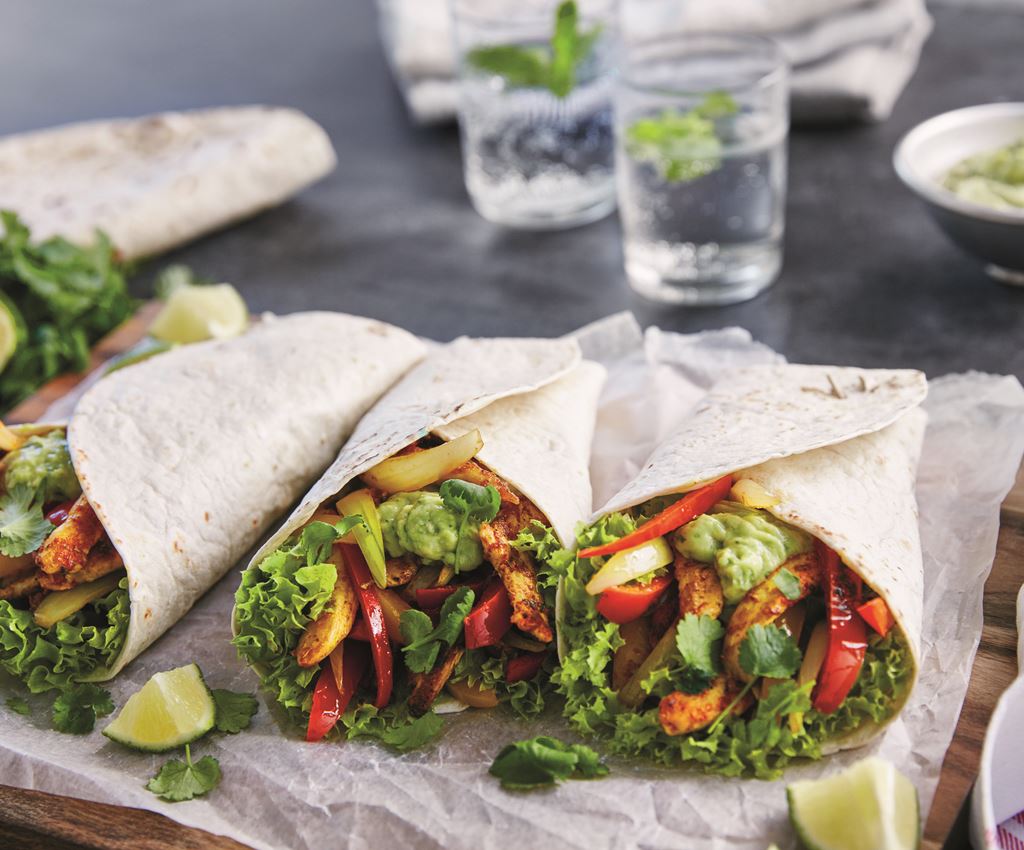 Klassieke fajita wraps met kip opgerold op een bord