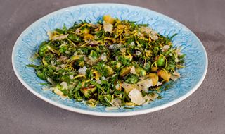 Stekt brysselkål med gremolata och parmesan på ett blått serveringsfat