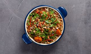 Ugnsform med vegetarisk biryani toppad med cashewnötter