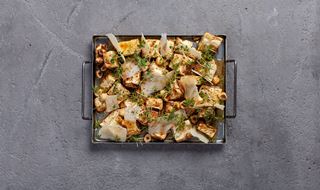 liten ugnsform med rostad rotselleri toppad med brynt vitlökssmör, parmesan och hasselnötter