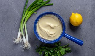 Blå kastrull med rotselleripuré omgiven av citron och sticklök