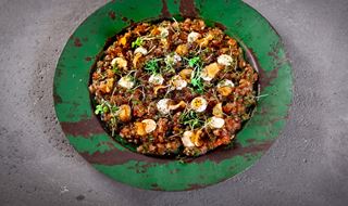 Tomattartar toppad med chips av jordärtskocka på ett grönt fat